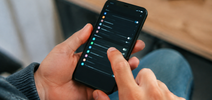 Mains touchant ecran parametres sur telephone noir