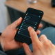 Mains touchant ecran parametres sur telephone noir