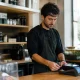 Commercant debout derriere son comptoir branchant un terminal