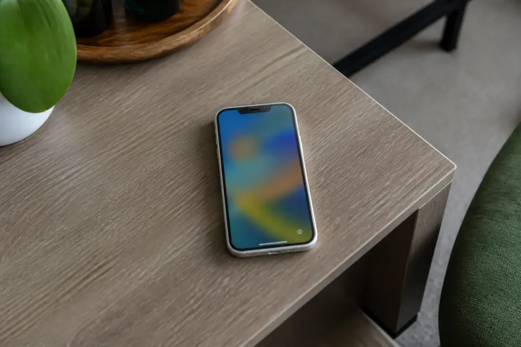 Iphone blanc pose sur table, ecran de configuration allume