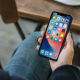 Main tenant un smartphone affichant une grille d'icones colorees