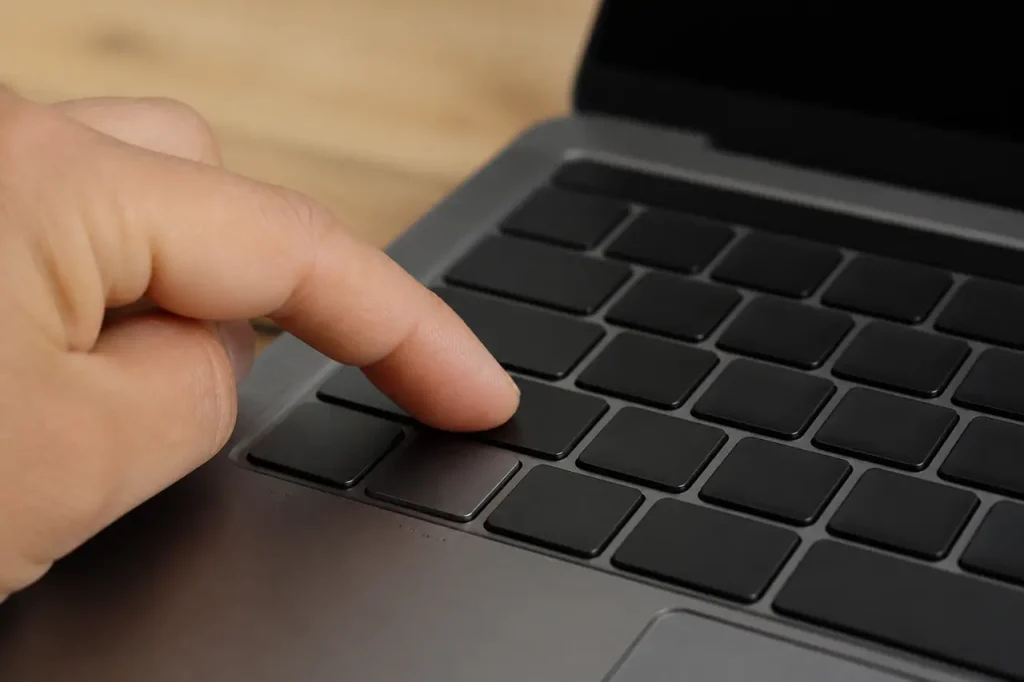 Ordinateur portable gris avec main pressant la touche Ctrl