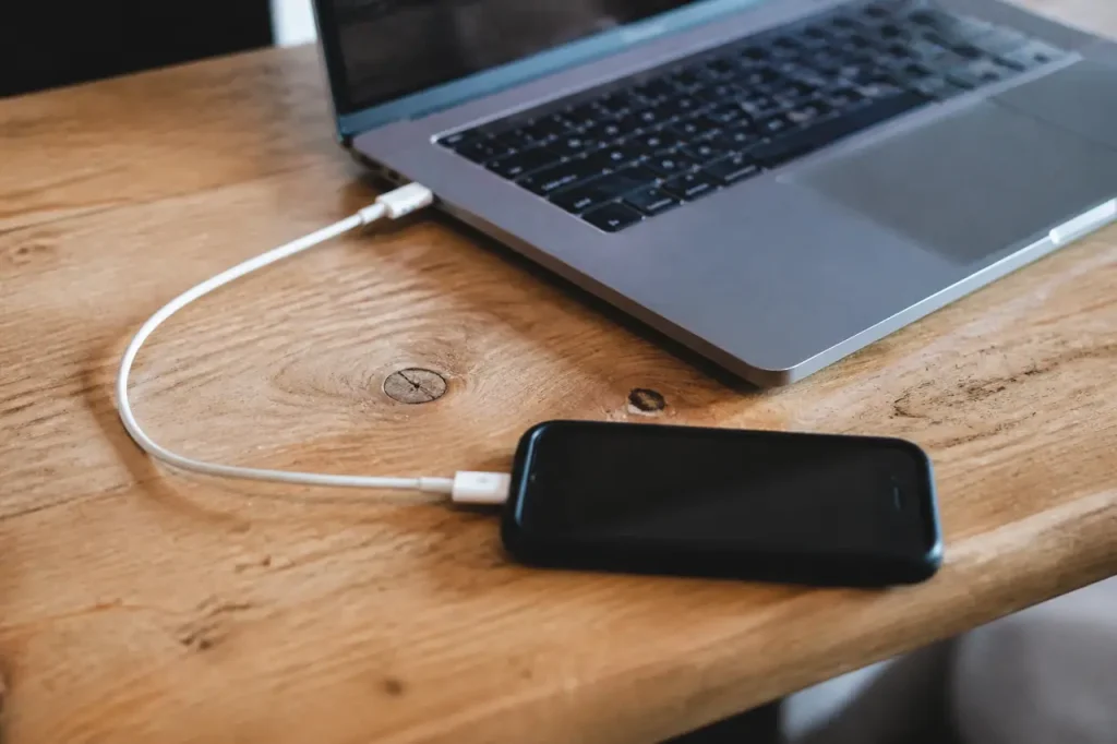 Ordinateur portable avec un iPhone branche par cable blanc