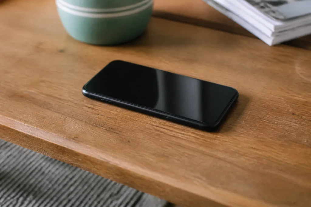 Smartphone noir pose sur un bureau en bois