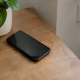 Smartphone noir ecran eteint couche sur table pres prise