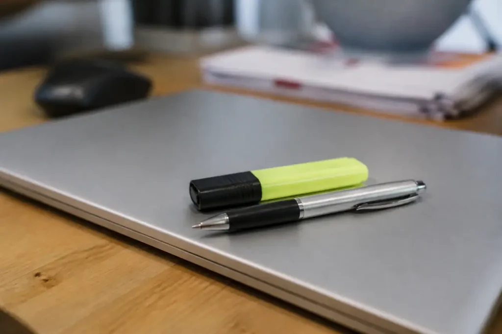 Stylo et surligneur posés sur un ordinateur portable