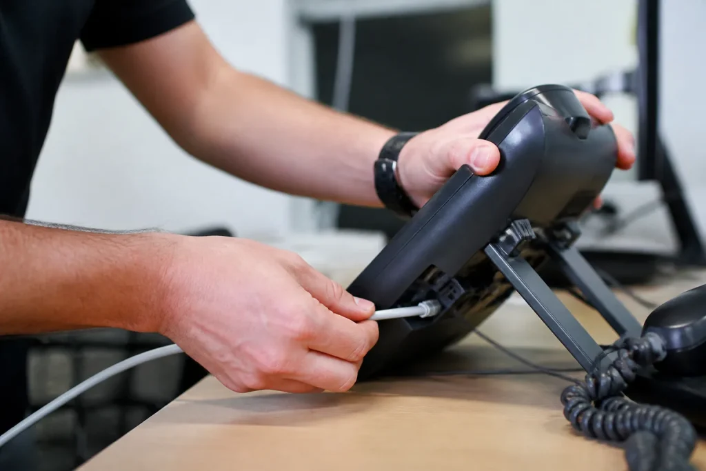 Technicien branchant un telephone IP et son cable