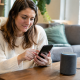 Utilisateur consultant smartphone pour configurer enceinte connectee
